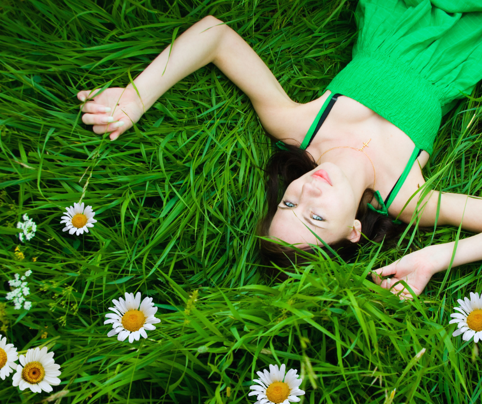 Lady dressed in green laying in the grass